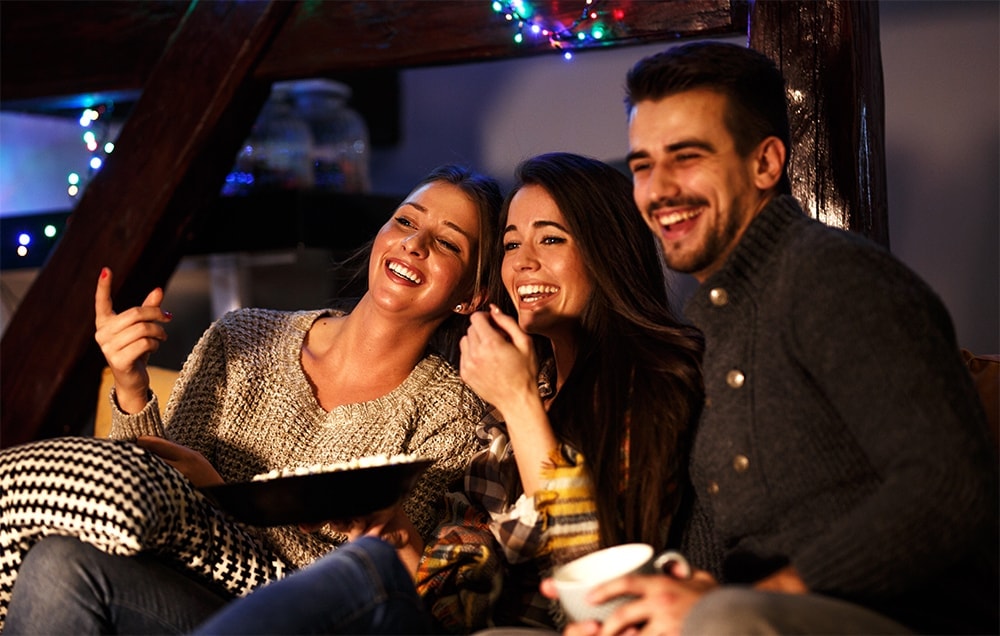 a throuple on a couch watching TV